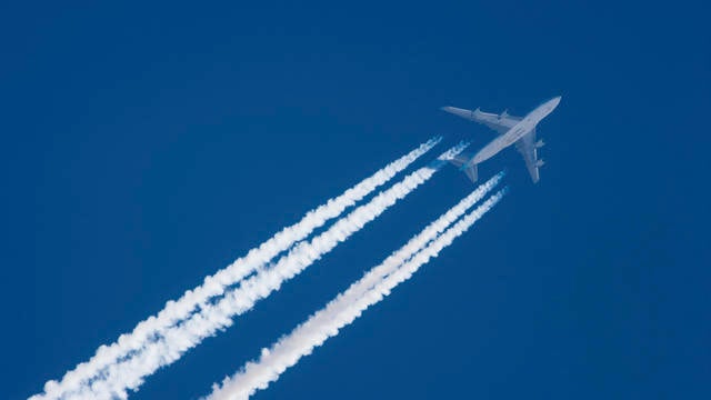 Jet plane in flight, leaving contrails behind 