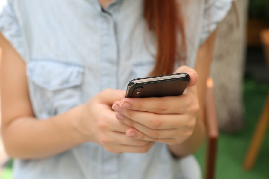 Woman using the best apps for personal trainers to talk to her coach.