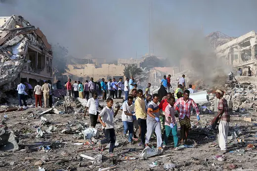 Civilians carry the dead body of an unidentified man from the scene of an explosion in Mogadishu.