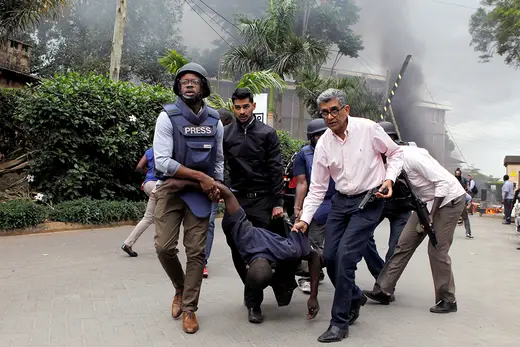 Rescuers and journalists evacuate an injured man from the Dusit hotel compound in Nairobi, Kenya.