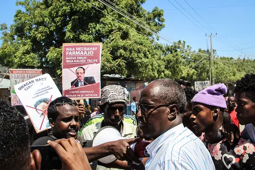 People hold posters during a protest against Farmaajo in Mogadishu.