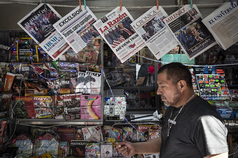 A man works at his newspaper kiosk displaying front pages with news about the US presidential election in Mexico City.