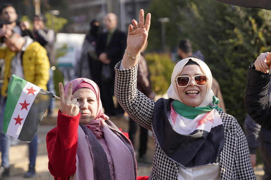 Women gesture as they celebrate after President Bashar al-Assad's authoritarian rule has ended.