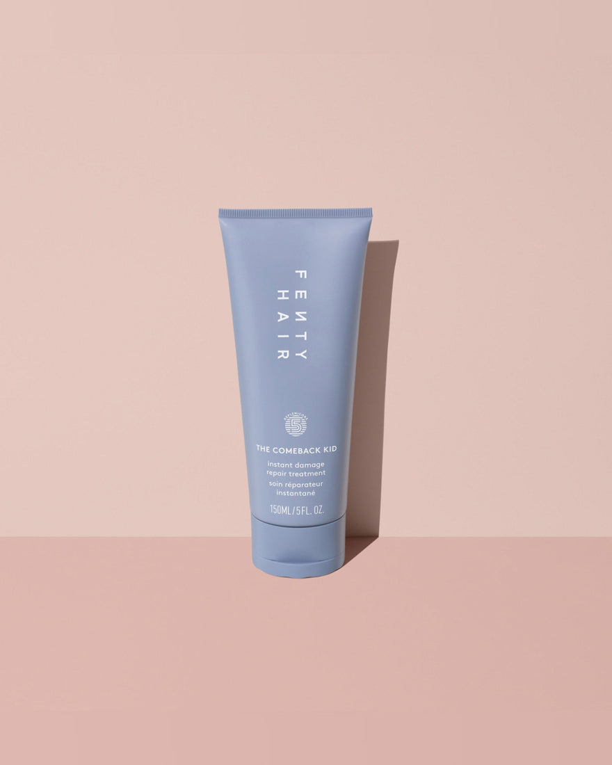 Fenty Hair The Comeback Kid Instant Damage Repair Hair Treatment Bond Builder tube made of 50% post-consumer recycled plastic on a pink background.