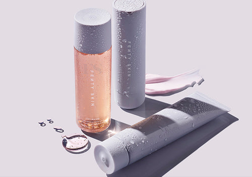 Product shot of Fenty Skin Start'rs and with water droplets on a lavender background.