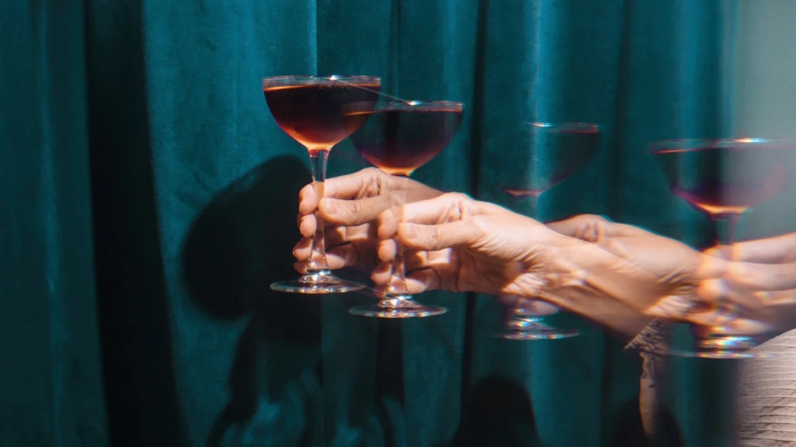 a hand holding a glass of wine