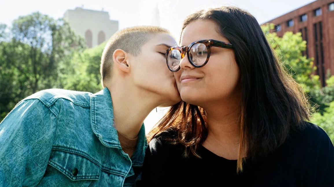 person kissing their partner's cheek