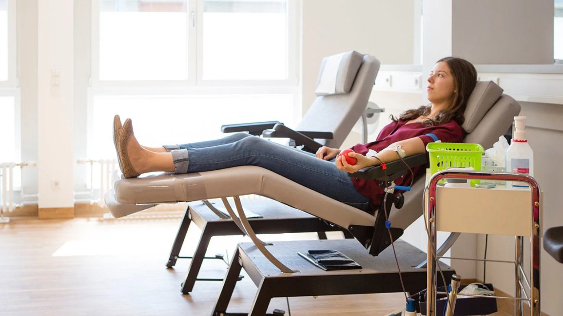 A young woman donating blood at a blood donation center. 