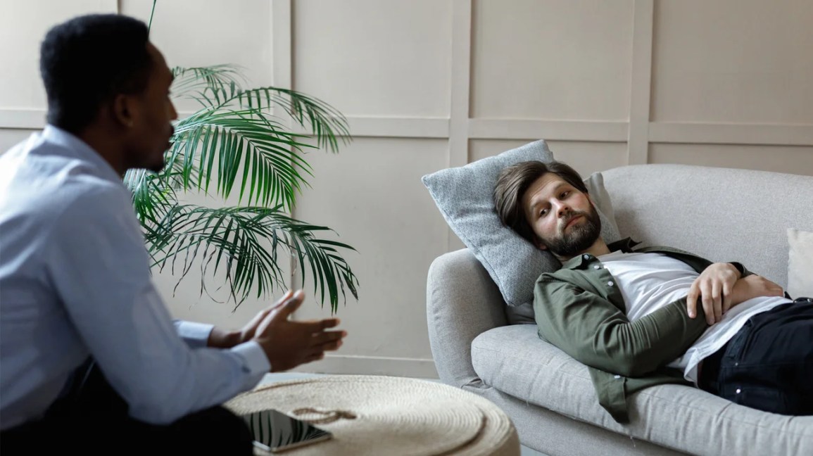 man laying on couch in psychotherapy office