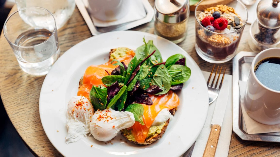 Image of toast topped with poached eggs and salad greens