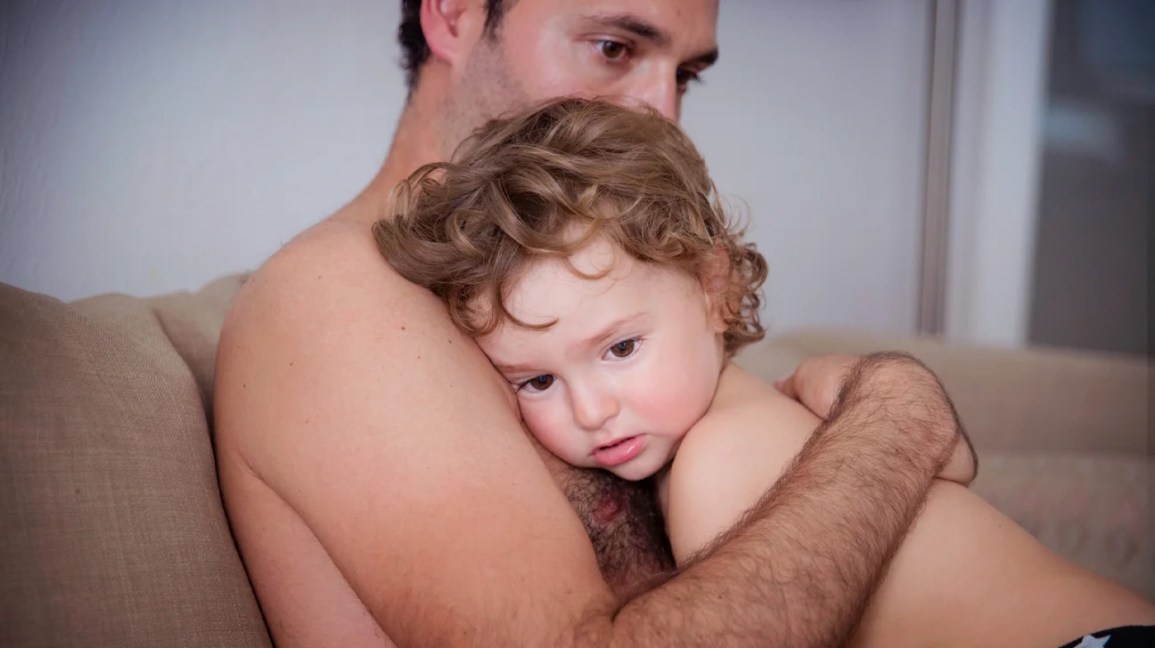 pediatric migraine, father comforting a young child