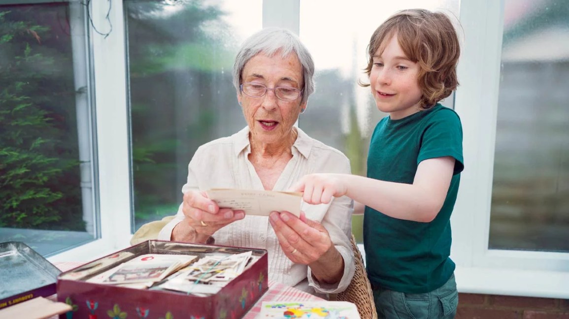 child helping grandmother read