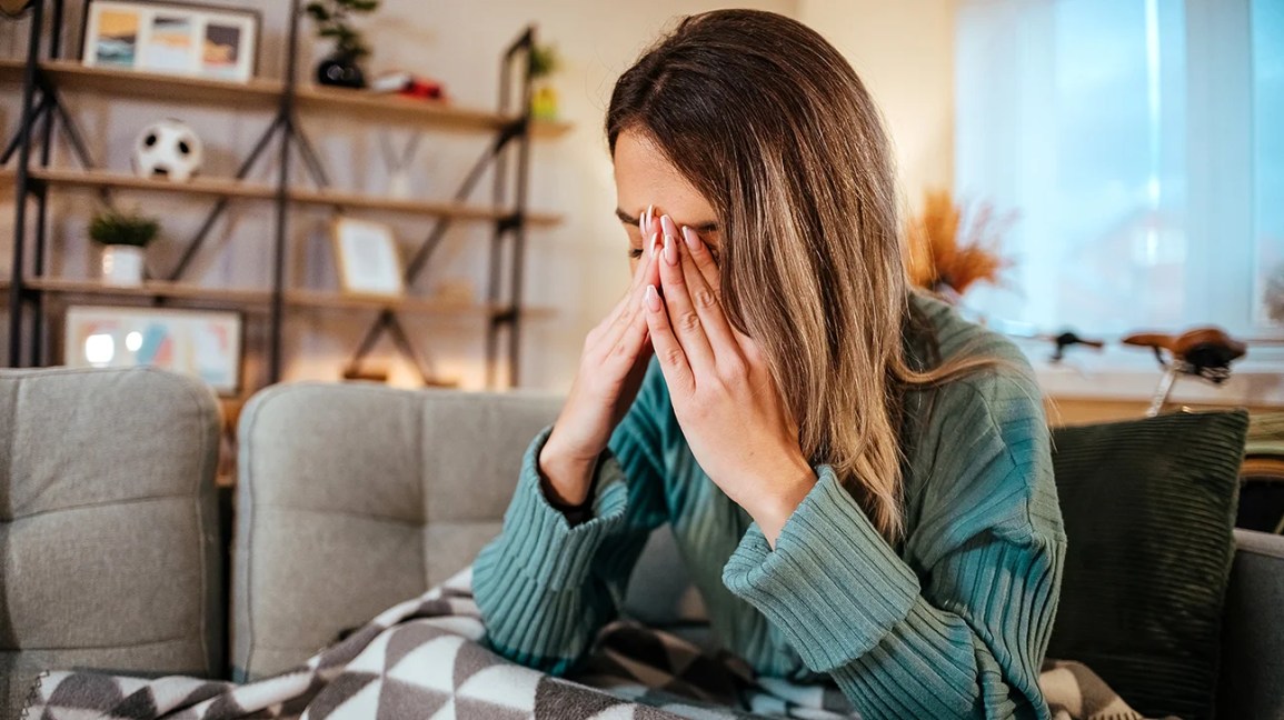 Woman with migraine on a couch.  