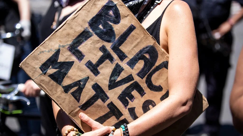 A white woman holds a Black Lives Matter sign at a protest in New York on June 12, 2020, USA. (Photo by Ira L. Black/Corbis via Getty Images)