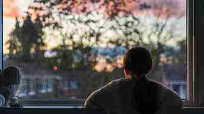 Rear view of young girl looking out the window.