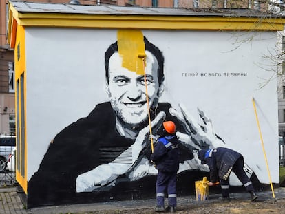 Un trabajador pinta sobre un grafiti con el retrato del opositor ruso Alexéi Navalni, el 28 de abril en San Petersburgo.
