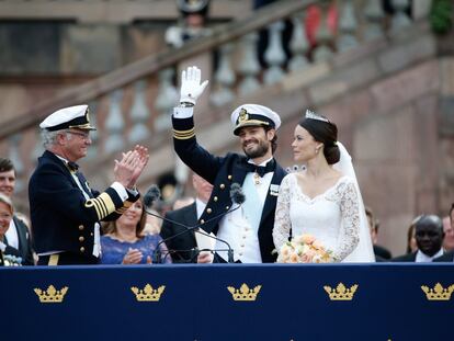 El Rey Carl XVI Gustaf de Suecia aplaude al príncipe Carl Philip y la Princesa Sofía de Suecia mientras saludan a la multitud después de salir de la capilla real de Palacio. 