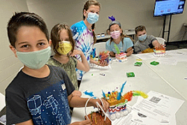 Campers decorate their Styrofoam skin blocks with cotton balls, pipe cleaners, and stickers.