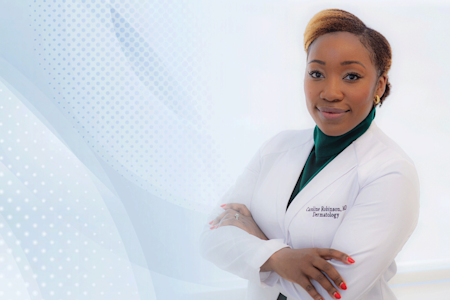 Female dermatologist smiling and wearing a white lab coat.