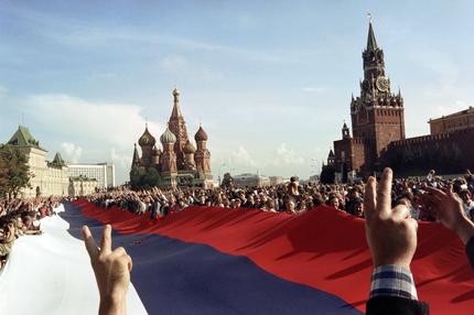 Ende der Sowjetunion: People holding a huge Russian flag flash victory signs on August 22, 1991 on Red Square in Moscow as they celebrate the failure of a hardline communist-led coup which nearly toppled Soviet President Mikhail Gorbachev. The coup was headed 19 August by the members of the self-styled "committee for the state of emergency" or the "gang of eight", including Soviet Vice President Gennady Yanayev and KGB chief Vladimir Kryuchkov. The same day, thousands in Moscow, Leningrad and other cities answered Russian Republic President Boris Yeltsin's call to raise barricades against tanks and troops. The collapse of the coup was signaled in the afternoon 21 August when the defence ministry ordered all troops to withdraw from Moscow.