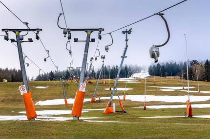 Ski-Tourismus: Der stehende Skilift und Schneereste am Skihang am Fichtelberg in Oberwiesenthal am 07.01.2023. Fehlender Schnee und zu warme Temperaturen für die Beschneiungsanlagen lassen keinen Wintersport in den Skigebieten im Erzgebirge zu.