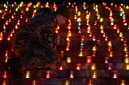 Lage in der Ukraine: A military cadet lights a candle during a commemorative ceremony on the 1000th day of Russia's full scale attack on Ukraine, in front of the 'Motherland' monument in Kyiv, Ukraine November 19, 2024. REUTERS/Valentyn Ogirenko