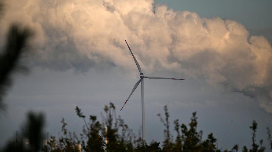 Klimaschutz: This picture taken on November 12, 2024 shows a wind turbine near the lignite-fired power station operated by German energy giant RWE at Neurath, western Germany.