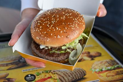 Nachhaltigkeit: Eine Frau hält einen Burger M beim Opening-Event der McDonalds Filiale in der Alboinstraße in den Händen. Der M besteht aus zwei saftigen Patties aus Rindfleisch aus Deutschland und einer cremigen Special Sauce.