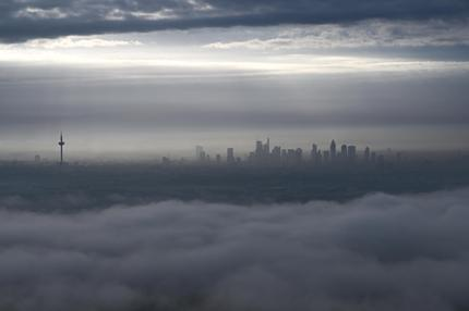 Deutscher Wetterdienst: 2023-10-05 Während am frühen Morgen eine Wolkenschicht über den Taunusrand zieht, fällt Sonnenlicht durch Wolkenlücken auf die Frankfurter Skyline. +++ dpa-Bildfunk +++ Arne Dedert