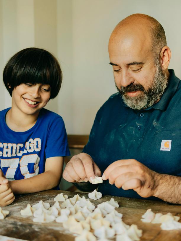 Mantı: Der Koch Koral Elci mit seinem Sohn Juni, während sie gemeinsam mit Tochter Lea (17) Mantı zubereiten, türkische Teigtaschen. Sie entscheiden sich für eine Variante mit veganem Hack, einer Joghurtsauce und Pesto. In der Wohnung der Familie in Hamburg, 07.07.2023