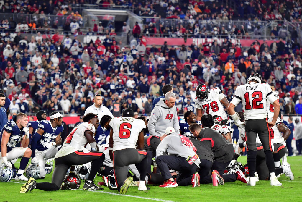 Players look on during an injury timeout for Russell Gage