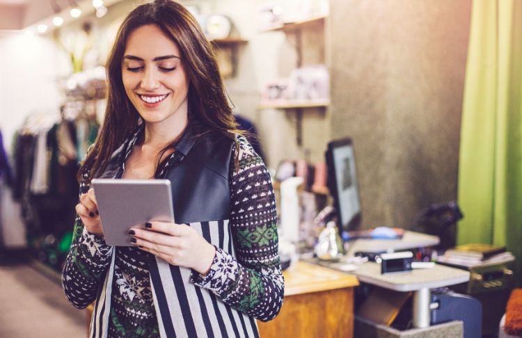 january social media holidays - female business owner holding ipad in store