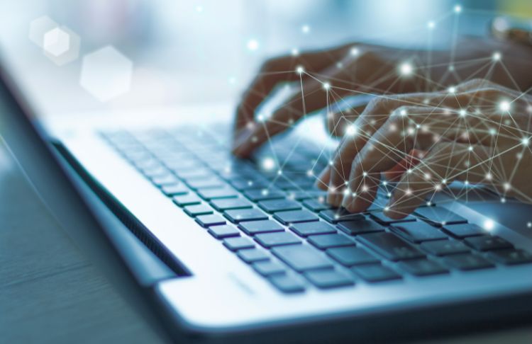 person typing on laptop with ai technology lines on top of hands