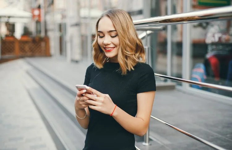 Geofencing examples - Woman looks at her phone outside of a restaurant