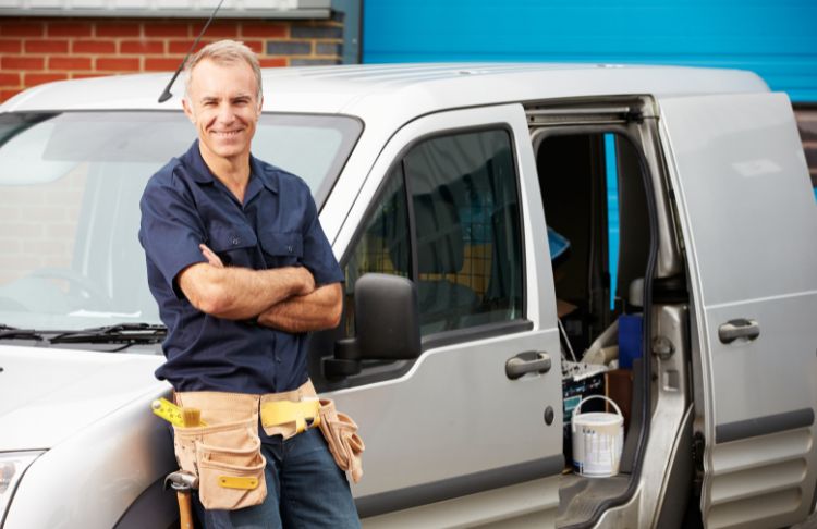 home services technician standing outside of work van