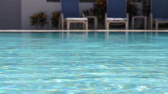 How does chlorine work to clean swimming pools?