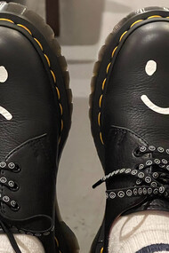 Sapatos pintados com um sorrio triste e outro sorriso feliz refletem nossas alegrias e dores em estados diferentes ao longo da vida