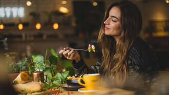 Mulher apreciando comida. Além de alimentar o corpo, a comida também promove o senso de pertencimento