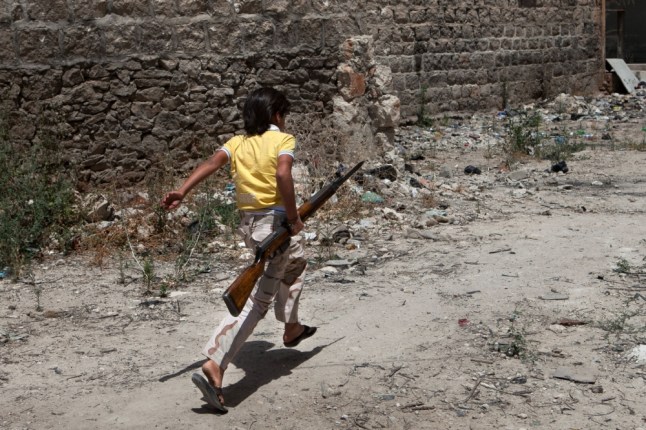 A Syrian young boy runs holding an old rifle as he helps fighters belonging to the "Martyrs of Maaret al-Numan" battalion on June 13, 2013 in the southern Syrian town of Maaret al-Numan in the Idlib province. At least 93,000 people, including over 6,500 children, have been killed in Syria's civil war, the United Nations said on June 13, 2013, warning that the true death toll could be far higher.  AFP PHOTO DANIEL LEAL-OLIVASDANIEL LEAL-OLIVAS/AFP/Getty Images