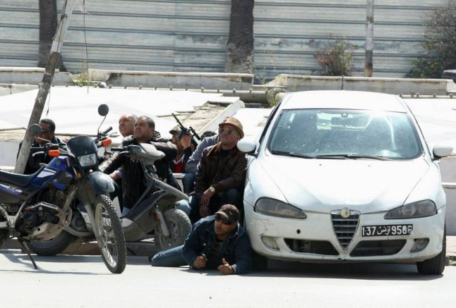 Police officers are seen on the pavement outside parliament in Tunis March 18, 2015. Gunmen attacked Tunisia's national museum near its parliament on Wednesday, killing at least seven tourists and taking others hostage inside the building, the government said.    REUTERS/Zoubeir Souissi (TUNISIA - Tags: CIVIL UNREST POLITICS)