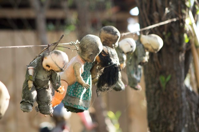 *** EXCLUSIVE *** XOCHIMILCO, MEXICO CITY - MARCH 27: A group of dolls hang from a washing line strung between two trees on Isla de las MuÒecas  on March 27, 2016 in Xochimilco, Mexico City.  Hidden in the Xochimilco canals is Mexicoís creepiest tourist attraction - Isla de las MuÒecas - Island of Dolls. When the islandís only occupant discovered the corpse of a drowned girl in the canal, he began hanging up dolls all over the island to ward off her spirit. A two hour trajinera ride down the canals, the island is only accessible by boat and has evolved into a terrifying destination for explorers. Photographer Sebastian Perez Lira took the ride from his home in Mexico City to capture the spooky dolls on camera. PHOTOGRAPH BY Sebastian Perez Lira  / Barcroft Images London-T:+44 207 033 1031 E:hello@barcroftmedia.com - New York-T:+1 212 796 2458 E:hello@barcroftusa.com - New Delhi-T:+91 11 4053 2429 E:hello@barcroftindia.com www.barcroftmedia.com