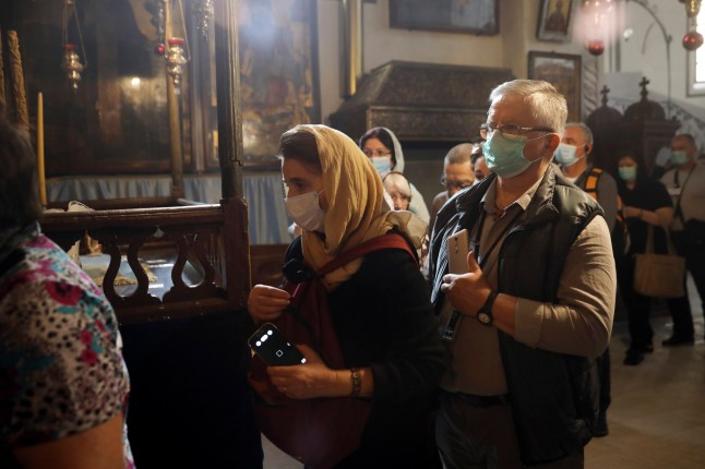 People visit the Church of the Nativity in Bethlehem, West Bank, Thursday, March 5, 2020. Palestinian authorities said the Church of the Nativity in Bethlehem, built atop the spot where Christians believe Jesus was born, will close indefinitely due to coronavirus concerns. (AP Photo/Mahmoud Illean)