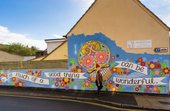 CXX1M6 Mural street art on a wall in Glastonbury, Somerset, UK - skull / day of the dead