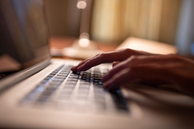 Cropped student using laptop in evening