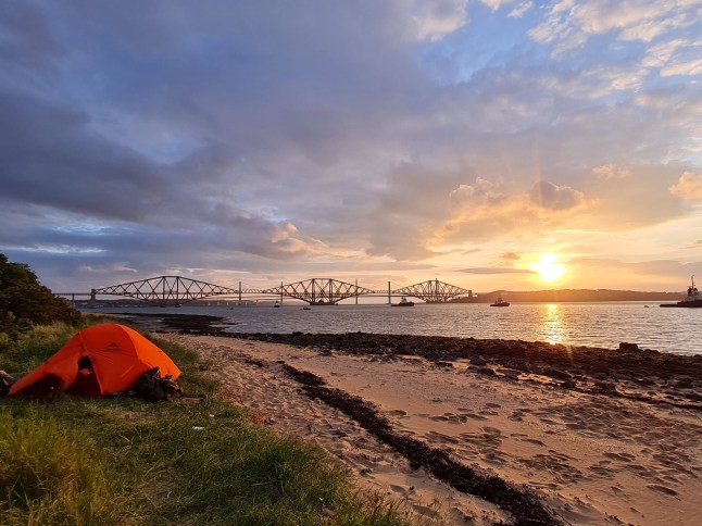 Tent next to coast with sunset