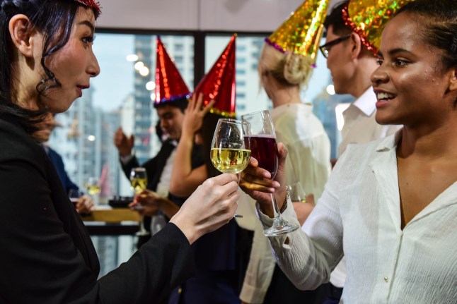 Business men and women with glasses of champagne and wine celebrating