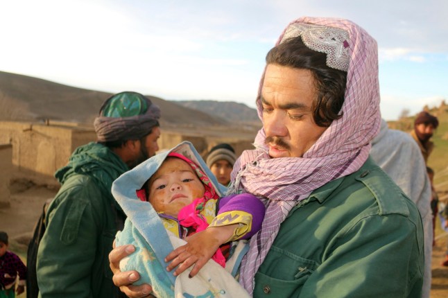 An Afghan man hold his injured daughter after his home was damaged by Monday's earthquake in the remote western province of Badghis, Afghanistan, Tuesday, Jan. 18, 2022. The United Nations on Tuesday raised the death toll from Monday's twin earthquakes in western Afghanistan, saying three villages of around 800 houses were flattened by the temblors. (Abdul Raziq Saddiqi)