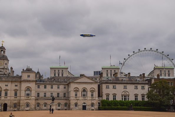 A Goodyear blimp flying over Horse Guards Parade in London