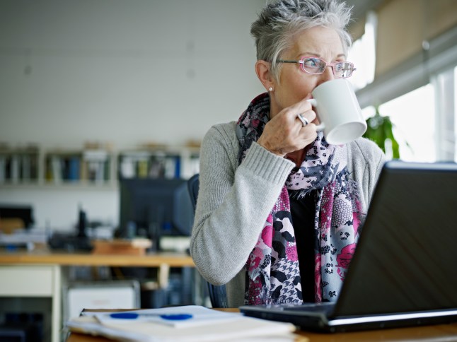 Businesswoman sitting in office drinking coffee