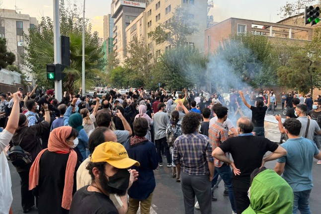 People gather during a protest for Mahsa Amini, a woman who died after being arrested by the Islamic republic's "morality police", in Tehran on September 19, 2022. - Fresh protests broke out on September 19 in Iran over the death of a young woman who had been arrested by the "morality police" that enforces a strict dress code, local media reported. Public anger has grown since authorities on Friday announced the death of Mahsa Amini, 22, in a hospital after three days in a coma, following her arrest by Tehran's morality police during a visit to the capital on September 13. (Photo by AFP) (Photo by -/AFP via Getty Images)